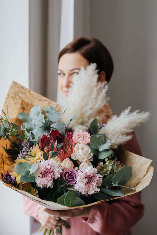 A woman with a bouquet wrapped in paper