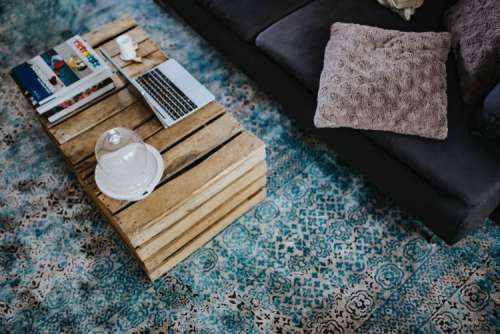 Designer living room interior with a wooden box table and a light blue carpet