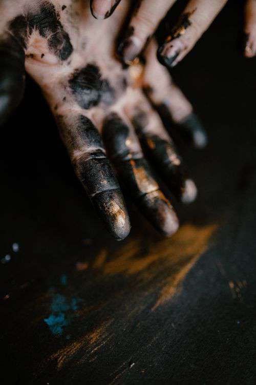 Messy painted hands of a painting artist