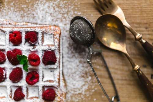 Breakfast waffles with fresh raspberries and powdered sugar