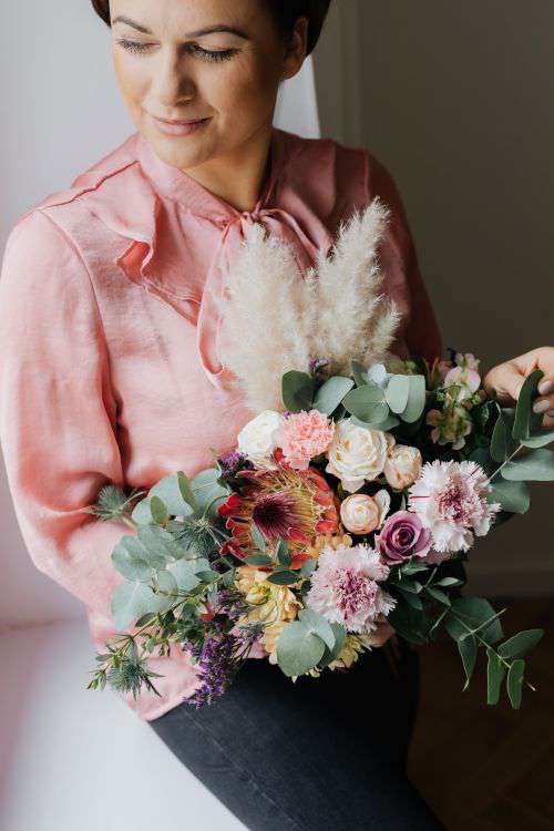 A woman with a bouquet wrapped in paper