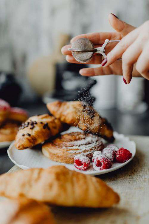 Croissants, puff pastry, powdered sugar and raspberries