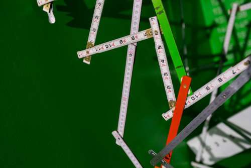 Extandable wooden ruler on a green background