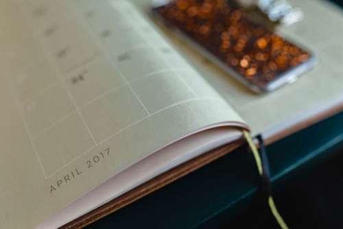 Home office desk with Macbook, iPhone, calendar, watch & organizer