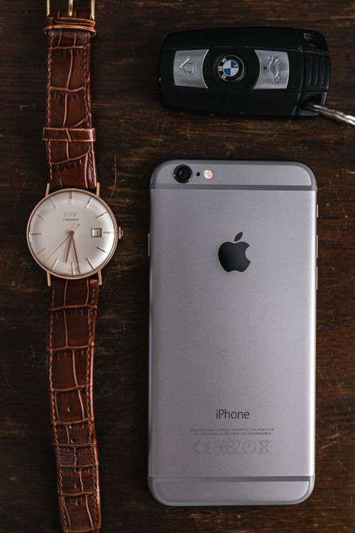 Apple iPhone 6 and Vintage watch on a brown leather wallet