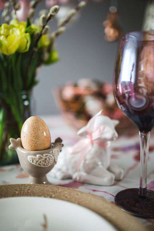 Easter table with cute pink decorations, flowers, catkins and eggs