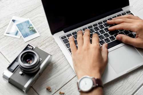 Photographer Typing Laptop Camera Desk Free Photo