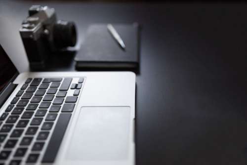 MacBook, Camera and Notepad Free Photo