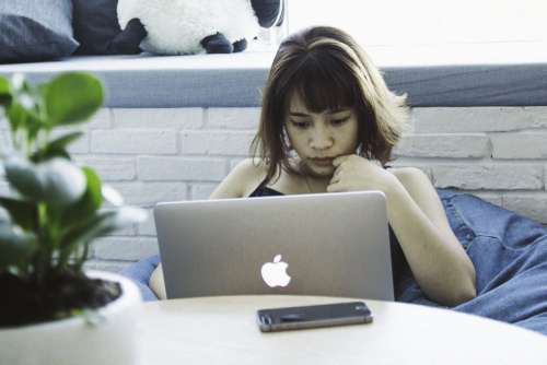 Woman on Beanbag using MacBook Free Photo