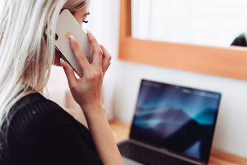 Woman Calling While Working on Laptop Free Photo