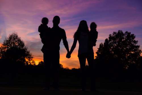 Beautiful couple with small children is holding hands on sunset (Nominated)