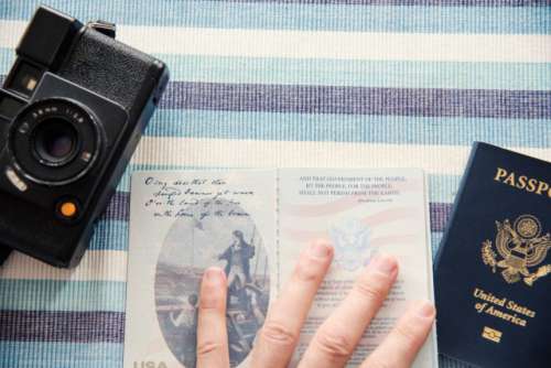 Close up overhead view of hand holding open a current US passport book with camera.