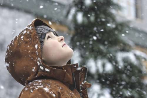 A boy marvels at falling snow