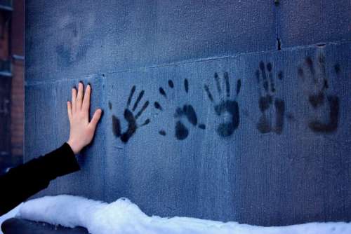 A woman's hand, leaving prints on a frozen wall