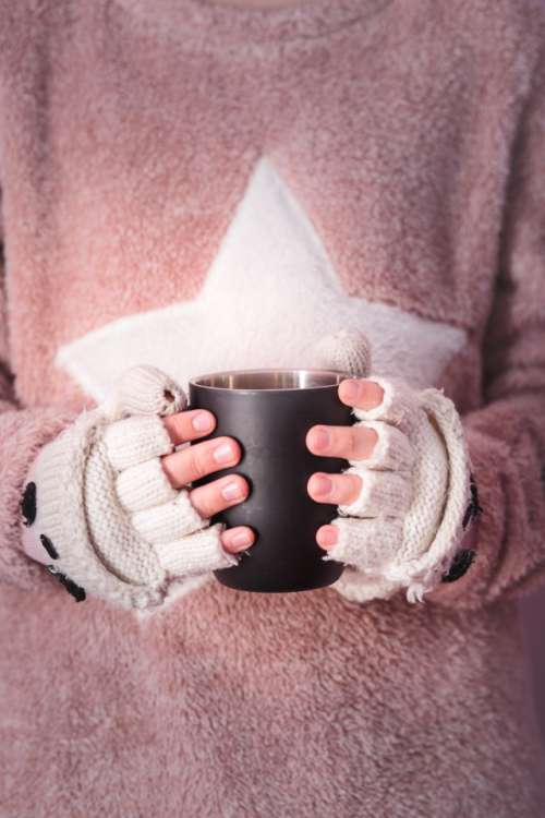 Female hands holding mug with hot drink