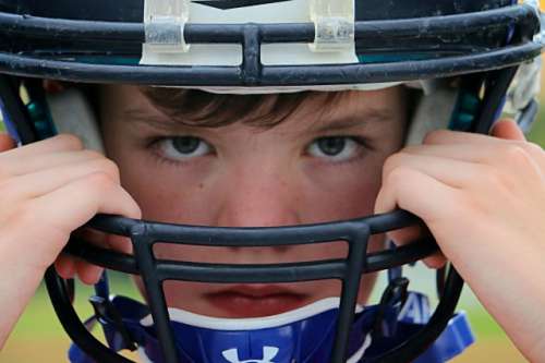 Portrait of young football player: Portrait, background, desktop, tabletop, people, human, face, expression, sports, sport, helmet, football, American football, athletics, athletic, athlete, drive, intense, one person, eyes, minimalistic, color, image, guard, equipment, youth, boy, no smile, team, league, season 