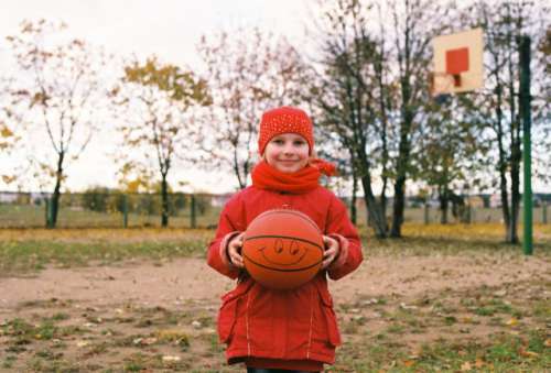 Little girl smiling and keep in her hands a ball after practice.