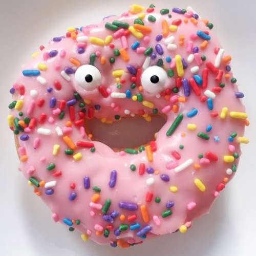Googly eyes on a pink sprinkled donut.