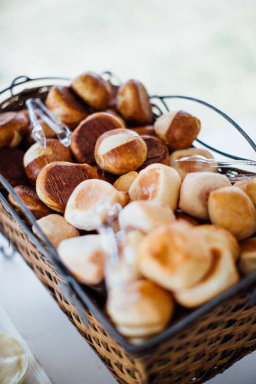 Rolls sit outside in a basket at a summer, outdoor, backyard wedding