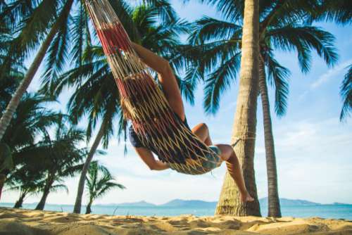 Woman chilling in hammock on the beach 