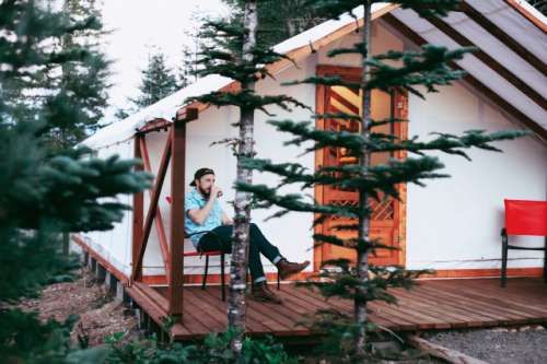 Young stylish man cabin camping 