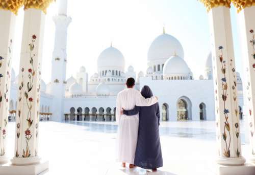 Travel: A Couple from behind at the Abu Dhabi white mosque. 
