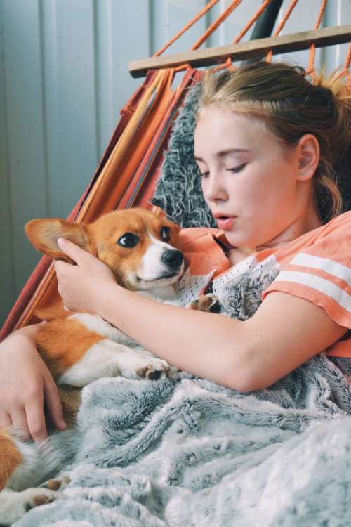 Girl talking to her dog in the hammock