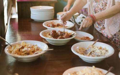 A woman serves herself pasta 