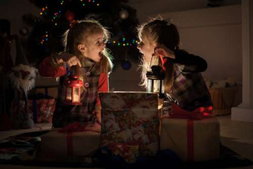 Christmas night. Two girls open the gifts under the tree. New year's stories. Real emotions.