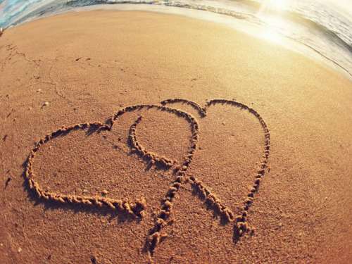 Two hearts interlocked in the sand 
