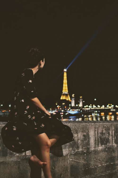 Beautiful girl watching the lights on the Eiffel Tower at the top of the hour.
