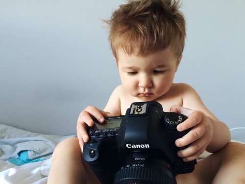 Little boy playing with camera.