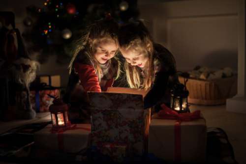 Christmas night. Two girls open the gifts under the tree. New year's stories. Real emotions