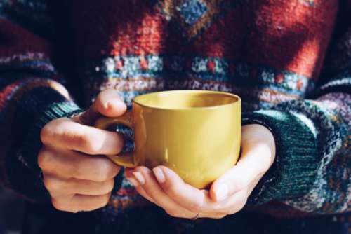 The girl is warmed by hot tea during an autumn season