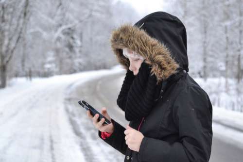 Girl with a smartphone and winter clothing