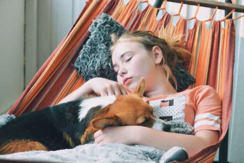 Girl and her dog sleeping in the hammock