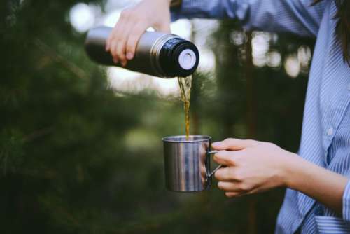 Woman traveler hands holding cup of tea the outdoors