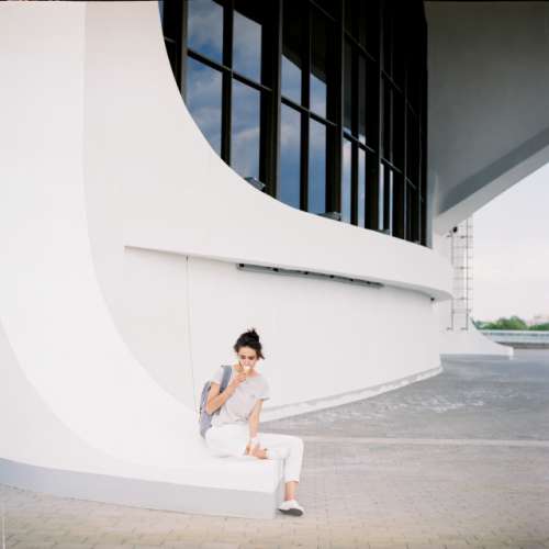 Girl sits and eats ice-cream. Film photo 120mm