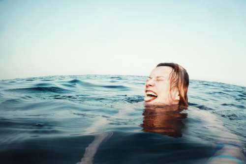 Happy woman swimming in the sea, selfie portrait by GoPro camera