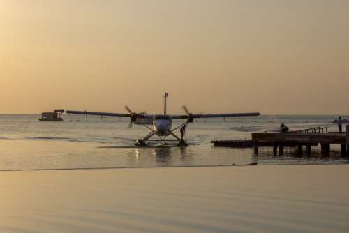 Sea Plane Landing at Tropical Beach Resort at Dawn