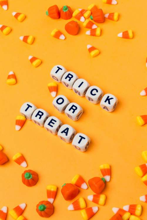 Trick Or Treat On An Orange Background With Candy Corn Photo