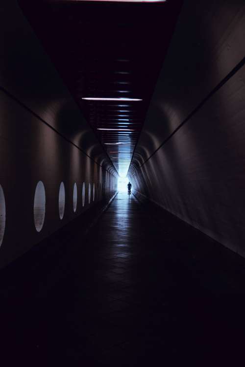 A Man Rides A Bicycle Through A Tunnel Photo