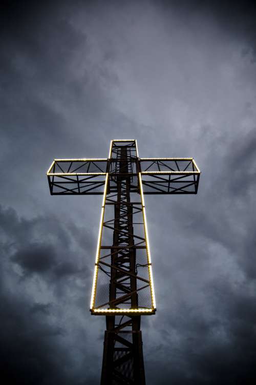 LED Lit Cross Against Stormy Sky Photo