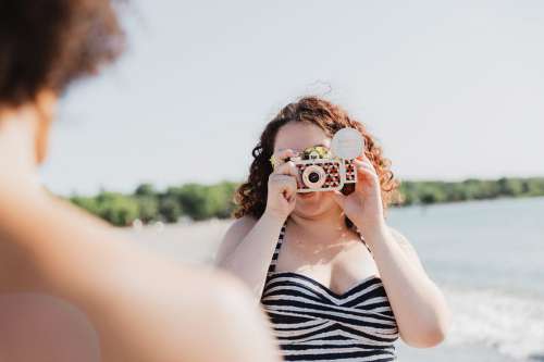 Young Woman In Swimwear Taking Photo With Colourful Camera Photo