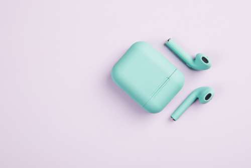 Green Earbuds And Case On White Surface Photo