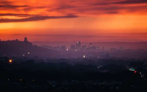 Red And Purple Sunset Over Hazy City Photo