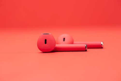 Pair of Red Earbuds On Red Surface Photo