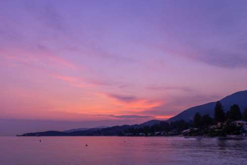 Purple Sunset Reflects Off Calm Coastal Waters Photo