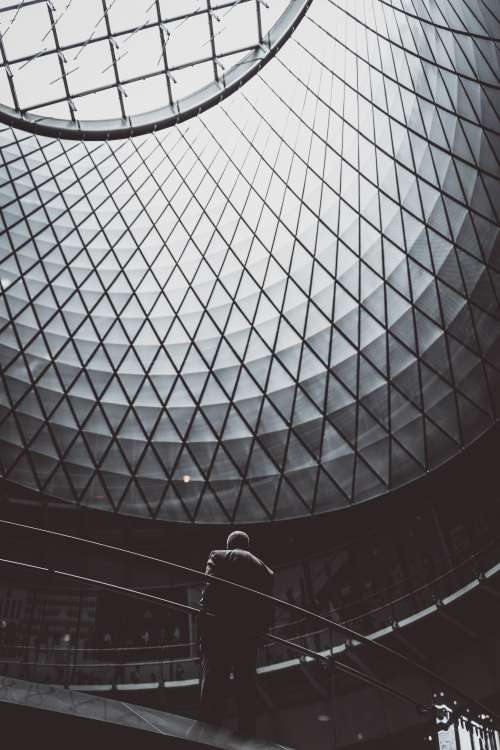 Man Stands Under Patterned Dome Window Photo