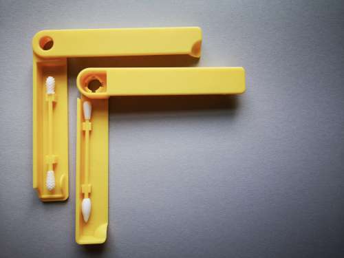 Two Plastic Yellow Q-Tips In Plastic Cases Photo